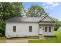 Charming single-story home with light gray siding, black roof, and a welcoming front porch with natural wood columns at 807 S Mebane St., Burlington, NC 27215