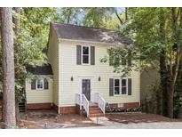 Charming yellow two-story home featuring a welcoming front porch, well-maintained lawn, and dark shutters at 1 Old Towne Pl, Durham, NC 27713
