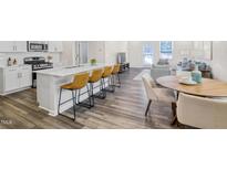 Modern kitchen featuring an island with bar seating and stainless steel appliances at 1007 Sora Way, Durham, NC 27703