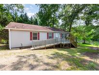 Quaint single-story home with a ramp, surrounded by lush greenery, nestled near a serene lake at 1033 Sagamore Dr, Louisburg, NC 27549