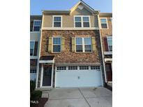 Charming multi-story townhome with brick and shingle siding, complemented by a convenient two-car garage at 1141 Boxcar Way, Apex, NC 27502