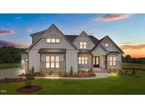 Charming two-story home features board and batten siding and stone accents, set on a well-manicured lawn at 120 Firefly Ln, Louisburg, NC 27549