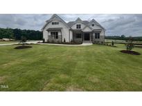 Charming two-story home with well-manicured lawn and stone accents at 120 Firefly Ln, Louisburg, NC 27549
