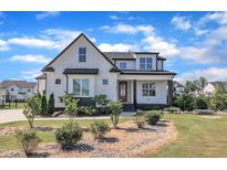 Beautiful two-story modern farmhouse with a landscaped yard and a stone-lined garden at 121 Nate Ct, Wake Forest, NC 27587