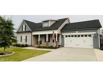 Charming two-story home with gray siding, a covered front porch, and an attached two-car garage at 137 Clydes Point Way, Wendell, NC 27591