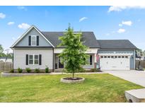 Charming two-story home with a manicured lawn, two car garage, and a welcoming front porch at 137 Clydes Point Way, Wendell, NC 27591