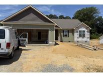 View of a home under construction, featuring a two-car garage and green siding at 145 Tee Dr, Selma, NC 27576