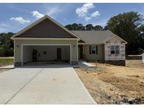 Charming single-story home with attached garage and well-lit entranceway on a sunny day at 145 Tee Dr, Selma, NC 27576