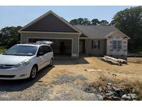 New home featuring a charming exterior with an attached garage and a clean landscape at 145 Tee Dr, Selma, NC 27576