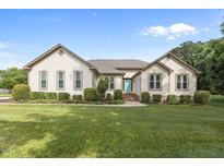 Charming, well-maintained ranch home with lush green lawn and a bright blue front door at 1614 E Hardscrabble Dr, Hillsborough, NC 27278