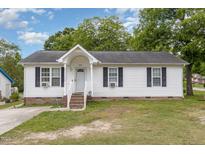 Charming single-story home with white siding, black shutters, and a well-manicured front yard at 205 Person St, Oxford, NC 27565