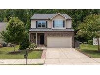 Charming two-story home with a stone facade and a two-car attached garage at 205 Willow Weald Ct, Fuquay Varina, NC 27526