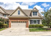 Charming two-story home with a brick and beige exterior and well-maintained landscaping at 215 Dungarven Loop, Cary, NC 27513