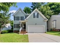 Charming two-story home featuring light-blue siding, black shutters, and an attached two-car garage at 2409 Horizon Hike Ct, Raleigh, NC 27603