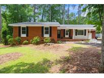 Charming brick home featuring a well-manicured lawn and mature trees at 2968 Tram Rd, Fuquay Varina, NC 27526