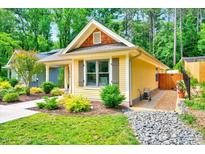 Charming yellow cottage-style home with well-manicured landscaping, stone pathway, and inviting curb appeal at 2975 Carolyn Dr, Durham, NC 27703