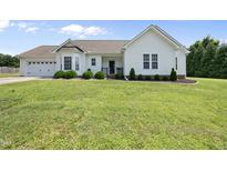 Charming white home with a well-manicured lawn, bay window, and attached two-car garage at 3705 Highland Creek Dr, Apex, NC 27539