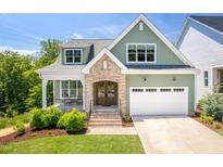 Charming two-story home with green siding, brick accents, and a well-manicured lawn at 386 Monteith Dr, Chapel Hill, NC 27516