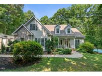 Charming two-story home featuring a stone facade, inviting front porch, and lush landscaping at 395 Timberlands Dr, Louisburg, NC 27549