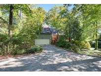 Beautiful home with attached garage nestled among trees, offering privacy and curb appeal at 403 Rutherglen Dr, Cary, NC 27511