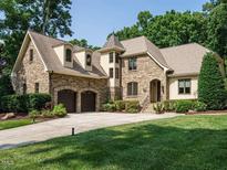 Stunning stone home with a two-car garage and manicured lawn at 410 Mountain Laurel, Chapel Hill, NC 27517