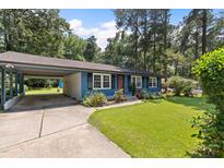Charming single-story home with blue siding, a well-maintained lawn and an attached carport at 509 Forest Ridge Rd, Garner, NC 27529