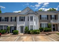 Inviting townhome with well-maintained landscaping and a charming front entrance, under a bright blue sky at 5209 Echo Ridge Rd, Raleigh, NC 27612