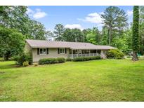 Charming single-story home with a metal roof, white porch railing, and a lush green lawn at 608 20Th St, Butner, NC 27509
