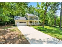 Charming two-story home with a well-manicured lawn, inviting front porch, and a long driveway at 7021 Oviedo Dr, Raleigh, NC 27603