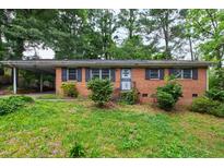 Charming brick ranch-style home featuring mature landscaping and a convenient carport at 720 Sherrybrook Dr, Raleigh, NC 27610