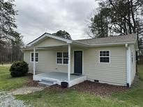 Charming single-story home featuring a covered porch, neutral siding, and well-maintained landscaping at 726 Thompson St, Pittsboro, NC 27312