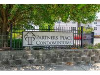 Partners Place Condominiums sign set in a black iron fence and stone base at 929 Morreene Rd # C31, Durham, NC 27705