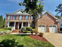 Charming two-story brick home with a well-manicured front yard and attached two-car garage at 9409 Collingdale Way, Raleigh, NC 27617