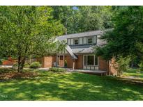 Charming brick home with mature trees and inviting front yard at 106 Wolfs Trl, Chapel Hill, NC 27516