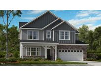 Charming two-story home with stone accents, a covered porch and a well-manicured front lawn at 1201 Michelle Mist Way, Apex, NC 27523