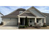 Charming home with a covered porch, attached garage, and manicured landscaping at 1205 Steinbeck Dr, Durham, NC 27703