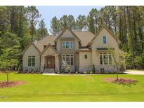 Beautiful two-story home with a stone and siding exterior and manicured lawn at 1212 Perry Bluff Dr, Wake Forest, NC 27587
