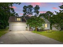 Charming home featuring a spacious driveway, two-car garage, manicured lawn, and inviting curb appeal at 153 Hickory Nut Dr, Smithfield, NC 27577