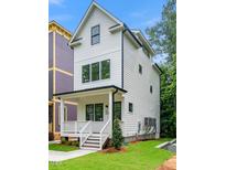 Charming two-story home with a welcoming front porch, black trim windows and a well-manicured lawn at 1621 Ella Wiggins Way, Raleigh, NC 27603
