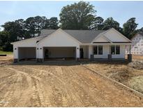 New construction home featuring a three car garage, white siding and stone accents at 165 Tee Dr, Selma, NC 27576