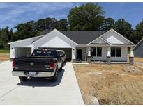 Charming single-story home featuring a white exterior, covered front porch, attached garage, and a well-manicured lawn at 165 Tee Dr, Selma, NC 27576