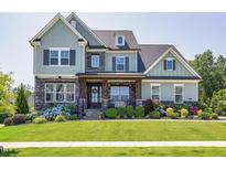 Charming two-story home with a landscaped front yard and inviting front porch at 205 Silent Cove Ln, Holly Springs, NC 27540