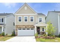 Charming two-story home featuring stone accents, a two-car garage, and a well-maintained front yard at 2264 Jollay St, Durham, NC 27703