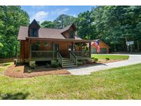 Charming log home featuring a covered porch, dormer windows, and a detached garage at 2416 Kearney Rd, Wake Forest, NC 27587