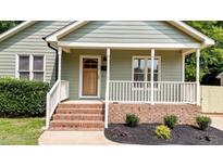 Charming front porch with brick steps, and a natural wood front door at 413 Top Greene Ln, Raleigh, NC 27601