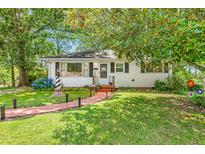 Charming single-story home featuring a brick walkway and well-maintained landscaping at 422 Hyde St, Burlington, NC 27217