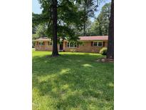 Charming brick ranch-style home with a lush green lawn and mature shade trees at 4618 Blanchard Rd, Durham, NC 27713