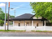 Charming renovated home with a fresh white exterior, black trim, a covered porch, and a picket fence at 516 Ottawa Ave, Durham, NC 27701