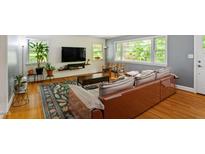 Inviting living room with hardwood floors, a large window, comfortable seating and colorful area rug at 7 Woodward Way, Chapel Hill, NC 27516