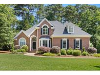 Charming brick home with manicured lawn, mature trees, and welcoming curb appeal at 103 Saint Brides Ct, Cary, NC 27518
